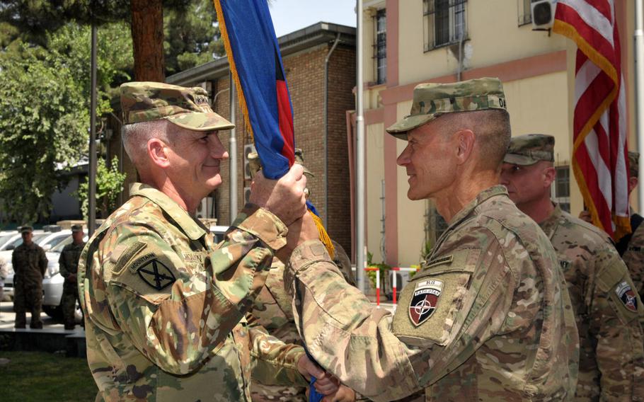 Maj. Gen. Gordon B. Davis Jr., right, outgoing commander of Combined Security Transition Command - Afghanistan, presents the guidon to Gen. John Nicholson, commander of U.S. and NATO forces in Afghanistan, during a change-of-command ceremony on Thursday, July 14, 2016, at NATO's Resolute Support headquarters in Kabul.