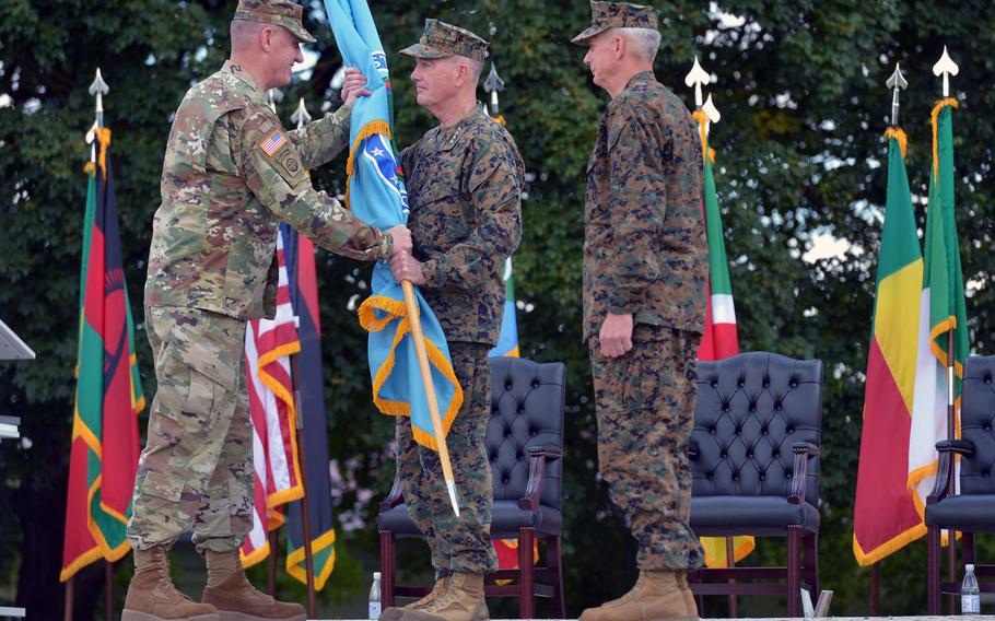 Outgoing commander Gen. David M. Rodriguez, left, hands the U.S. Africa Command colors to Joseph F. Dunford, chairman of the Joint Chiefs of Staff, as incoming commander Gen. Thomas D. Waldhauser watches. Waldhauser took command from Rodriguez at the ceremony at Patch Barracks in Stuttgart, Germany, Monday, July 18, 2016.