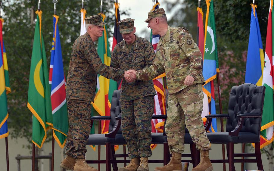 The new commander of U.S. Africa Command, Marine Gen. Thomas D. Waldhauser, left, shakes hands with his predecessor, Army Gen. David M. Rodriguez, as the chairman of the Joint Chiefs of Staff Marine Gen. Joseph F. Dunford looks on. Dunford presided over the change of command at Patch Barracks in Stuttgart, Germany, Monday, July 18, 2016.