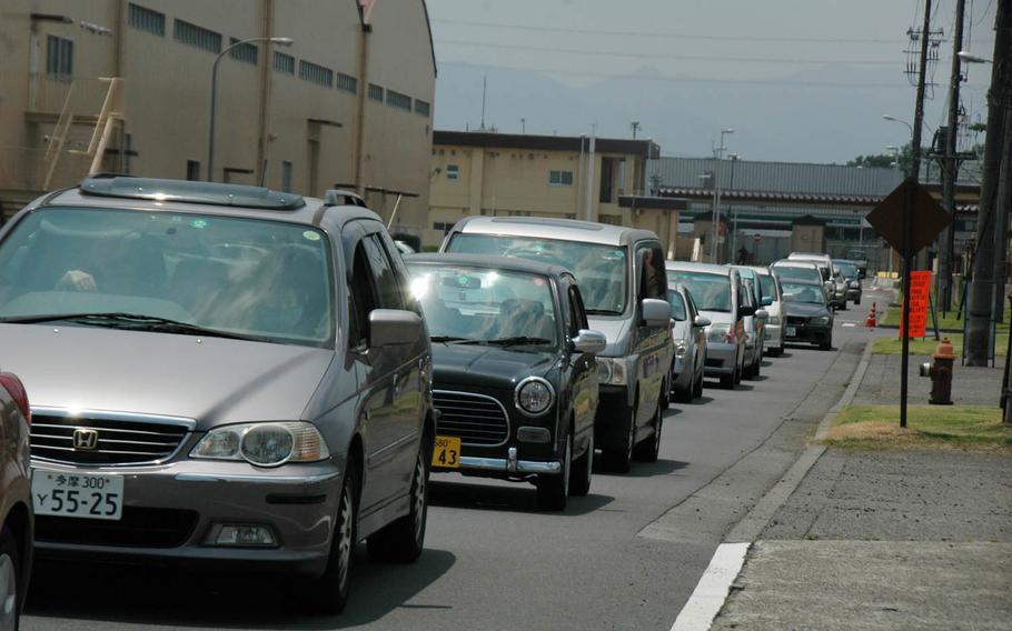 Drivers wait to cross the active runway at Yokota Air Base, Japan, headquarters of U.S. Forces Japan and 5th Air Force in western Tokyo. Lights control ground traffic crossing the runway, where, at any given time, one of the 374th Airlift Wing's C-130 Hercules transports might be landing or taking off.