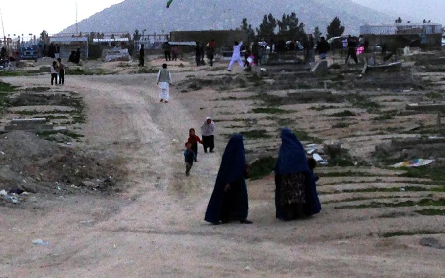 Two women in burqas visit a popular spot for flying kites in Kabul, Afghanistan, on April 15, 2016. Women in Afghanistan have enjoyed more freedom since the Taliban were ousted from power in 2001, but in some conservative corners of the country they still risk "dishonoring" their families if they are seen outside the home.