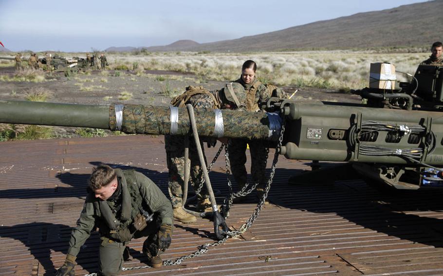 Marines prepare straps for the air hoist of an M777 howitzer cannon during a Rim of the Pacific excercise at Pohakuloa Training Area on the big island of Hawaii, July 19, 2016.
