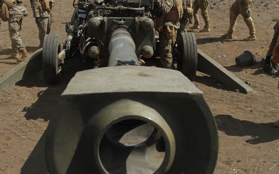 Artillerymen with Alpha Battery, 1st Battalion, 12th Marines, swarm around a howitzer cannon to prepare it for use at the live-fire range at Pohakuloa Training Area on the big island of Hawaii, July 19, 2016.