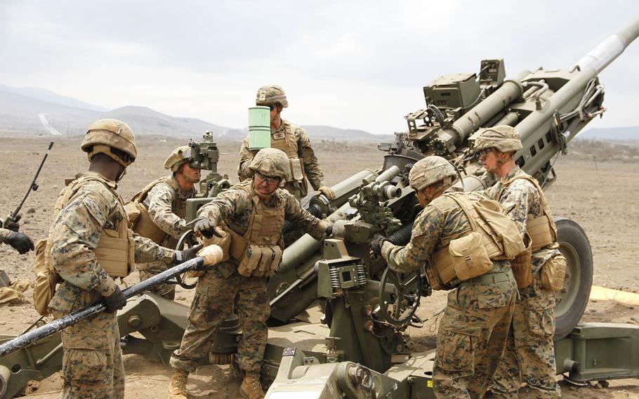 Marine cannoneers prepare to insert a charge into the barrel of a howitzer during an artillery raid at Pohakuloa Training Area, Hawaii, July 19, 2016, as part of the Rim of the Pacific exercise.