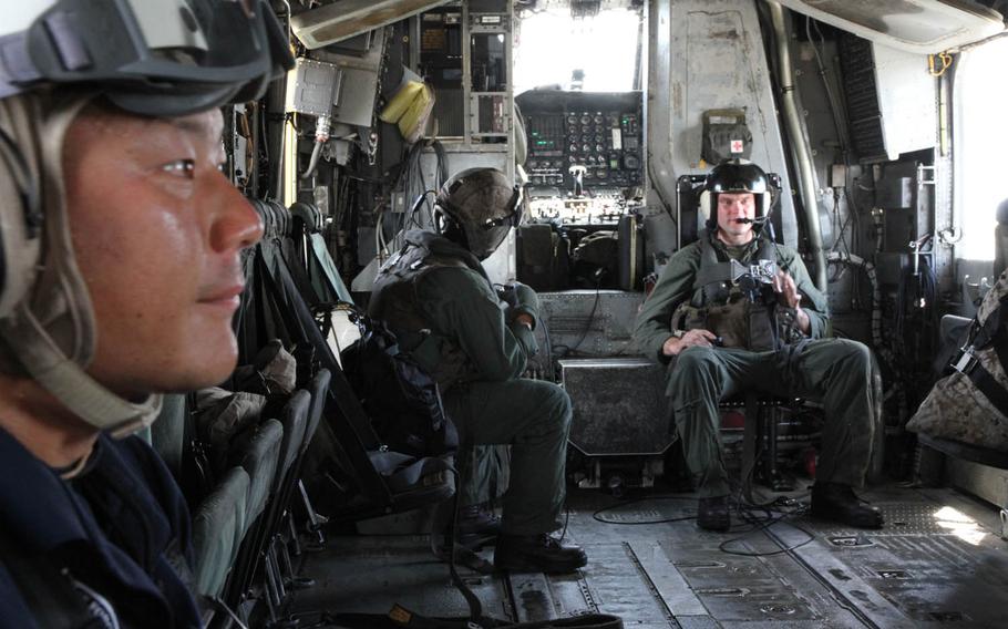 A Japan Ground Self-Defense Force soldier, left, prepares for takeoff aboard a Marine Corps CH-53E Super Stallion at Marine Corps Air Station Futenma on Thursday, July 21, 2016, during Japan's annual Churashima Rescue Exercise.