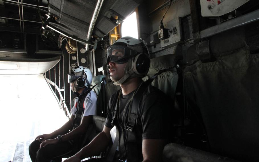 Two Japan Ground Self-Defense Force soldiers in civilian attire prepare for takeoff aboard a Marine Corps CH-53E Super Stallion at Marine Corps Air Station Futenma on Thursday, July 21, 2016. The Japanese soldiers were simulated casualties that needed evacuation from central Okinawa to first responders staging at Camp Naha in the south. This was the second year in a row Marines from Futenma participated in Japan's annual Churashima Rescue Exercise.