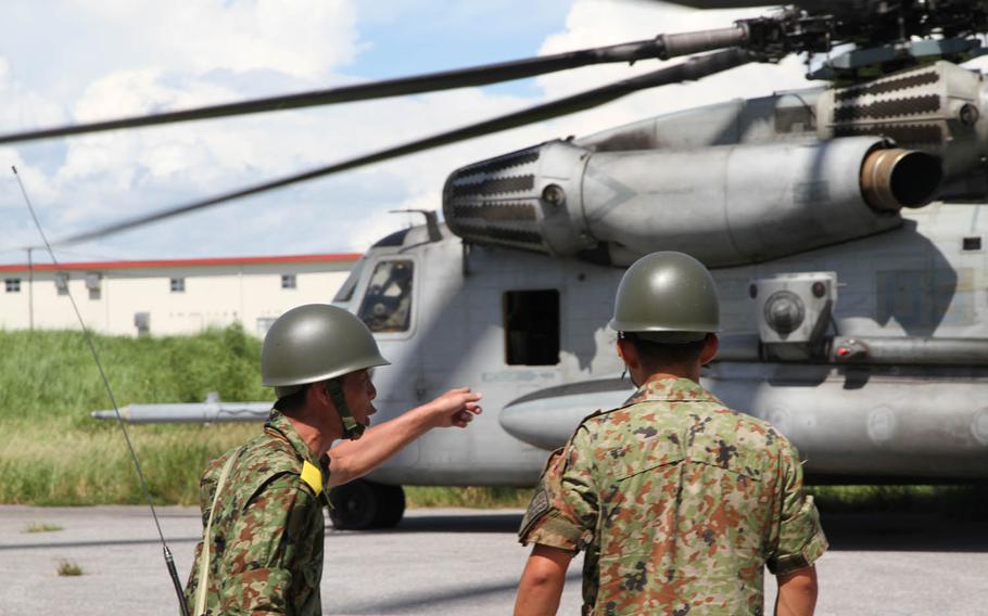 Two Japan Ground Self-Defense Force soldiers coordinate the Japanese response at Camp Naha in southern Okinawa on Thursday, July 21, 2016, shortly after a Marine Corps CH-53E Super Stallion landed carrying simulated wounded, during Japan's annual Churashima Rescue Exercise.