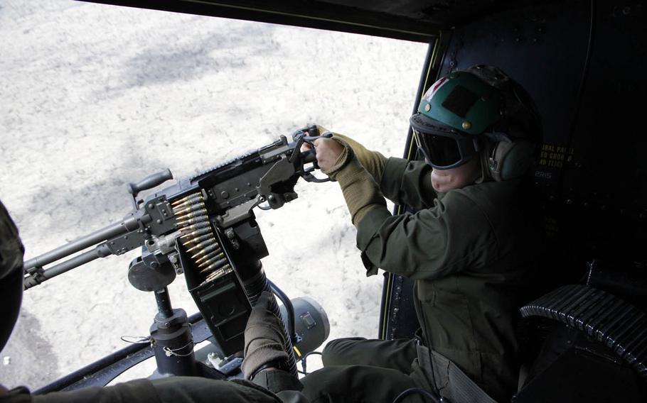 Marine Lance Cpl. Tiffany Moran has her first try at firing a M240 machine gun aboard a Huey helicopter during a tactical approach at Pohakuloa Training Area, Hawaii, July 20, 2016.