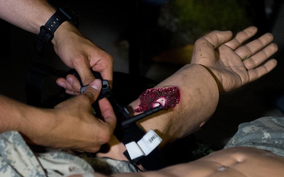 Pvt. Andrew Lepien applies a tourniquet to a simulated casualty during a demonstration for Ukrainian Army physicians in Baumholder, Germany, on Thursday, July 21, 2016.