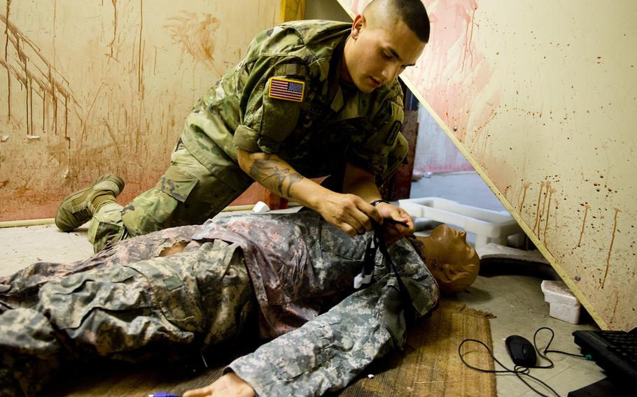 Pfc. Luis Pena, from the 557th Medical Company, applies a tourniquet to a simulated casualty during a demonstration for Ukrainian Army physicians in Baumholder, Germany, on Thursday, July 21, 2016.