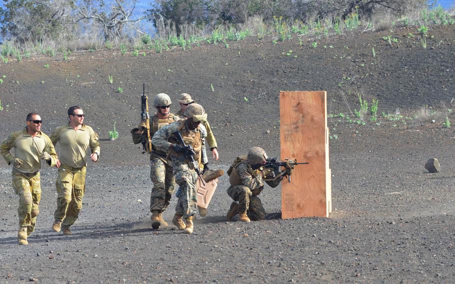 Marines dash to their next position carrying two filled water jugs simulating a casualty during a rifle contest at Pohakuloa Training Area, Hawaii, during RIMPAC 2016.