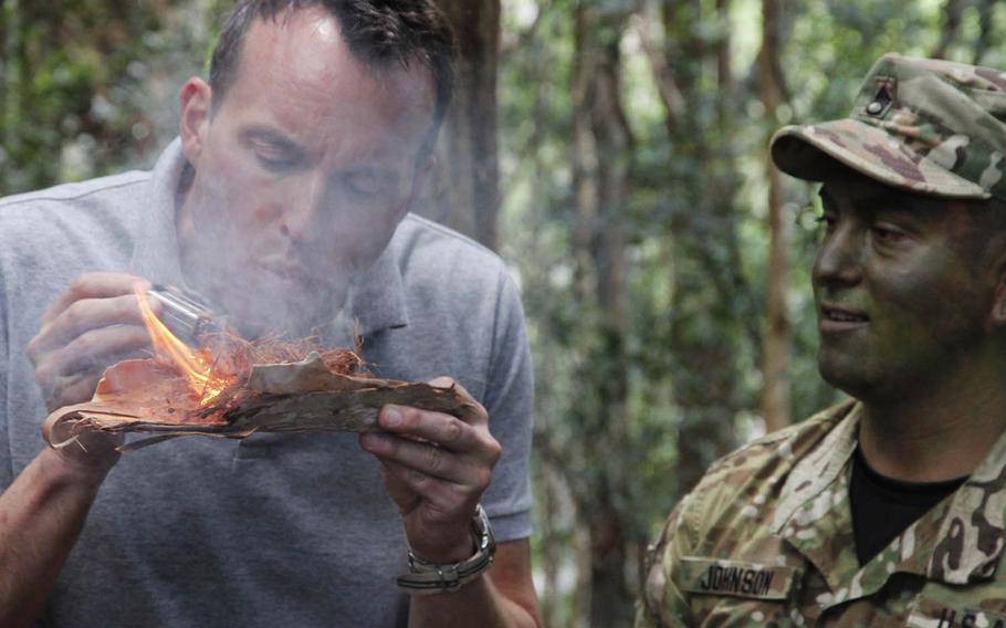 Secretary of the Army Eric K. Fanning creates fire from a 9-volt battery and steel wool during a tour of 25th Infantry Division's Lighting Academy jungle training in Hawaii, Tuesday, July 26, 2016. Fanning will also visit Guam, Japan and South Korea on his first tour of the Pacific since taking over the position in May.