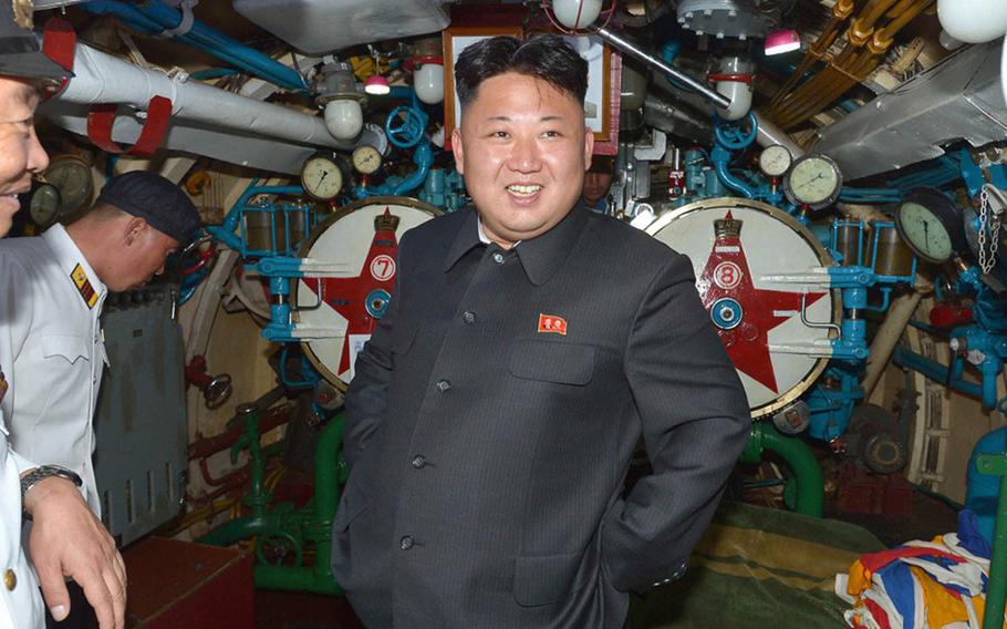 This undated photo from North Korea's official Korean Central News Agency shows North Korean leader Kim Jong Un inspecting a submarine while wearing a lapel pin featuring the images of his father, Kim Jong Il, and his grandfather, Kim Il Sung.