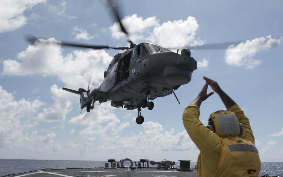 Boatswain's Mate 2nd Class Donte Ruffin signals to a South Korean helicopter as it takes off from the guided-missile destroyer USS Stethem in the South China Sea, May 6, 2016, during the at-sea phase of the ASEAN Defense Minister's Meeting.