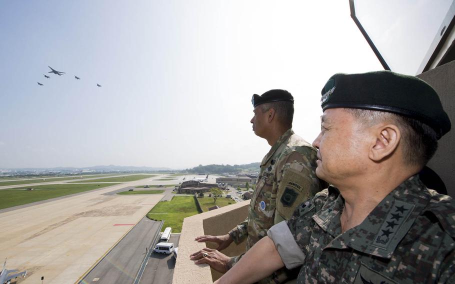 Gen. Vincent Brooks, U.S. Forces Korea commander, and South Korean army Gen. Lee Sun-jin watch an Air Force B-1B Lancer, escorted by South Korean fighter jets, performing a flyover at Osan Air Base, South Korea, Sept. 13, 2016.