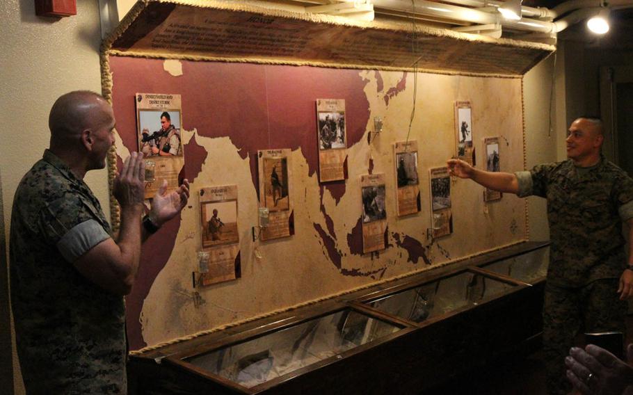 Maj. Gen. Richard Simcock II, left, and Marine Sgt. Maj. Vincent Santiago, both of the 3rd Marine Division, unveil a permanent display inside the division's headquarters at Camp Courtney, Okinawa, Friday, Sept. 16, 2016. The exhibit tells the division's story through uniforms, artifacts and jars of earth from nearly every conflict where its Marines fought and bled.
