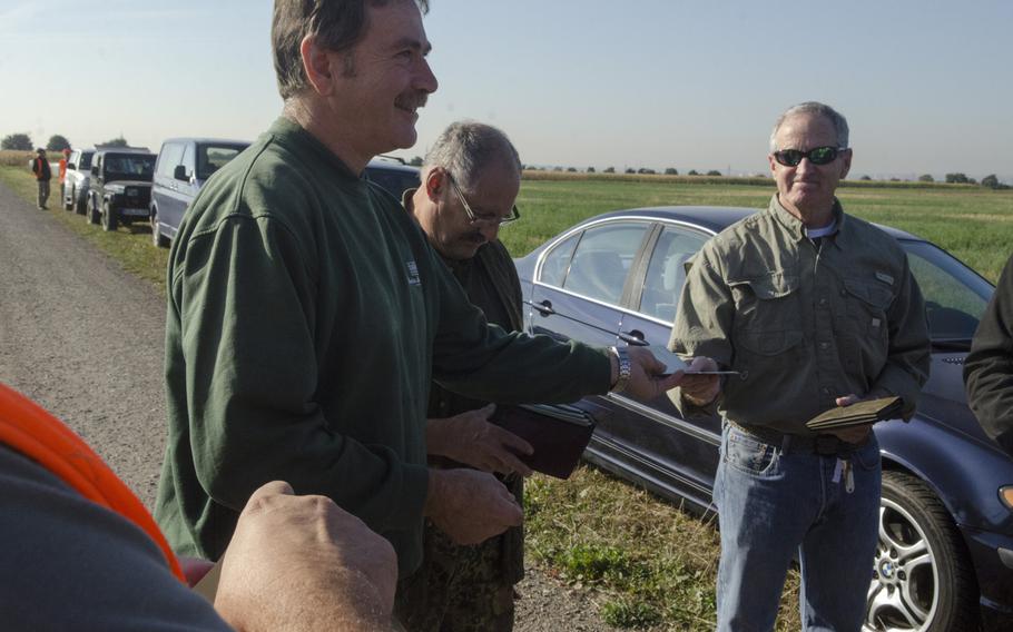 Stefan Diehl, left, orchard master at Domaene Mechtildshausen, a farm just outside Clay Kaserne in Wiesbaden, Germany, checks hunting licenses before he and others, including several Americans from Wiesbaden, take part in a hunt to aid local farmers rid their lands of pest animals, such as foxes, rabbits and crows, Thursday, Sept. 22, 2016.