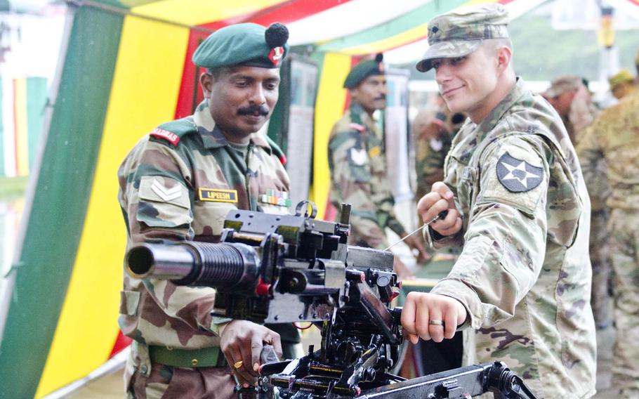 An Indian soldier shows a grenade launcher to a 1-2 Stryker Brigade Combat Team soldier from Joint Base Lewis-McChord, Wash., Sept. 15, 2016, in Chaubattia, India. The weapons demonstration was part of Yudh Abhyas, a bilateral training exercise that's in its 12th year.