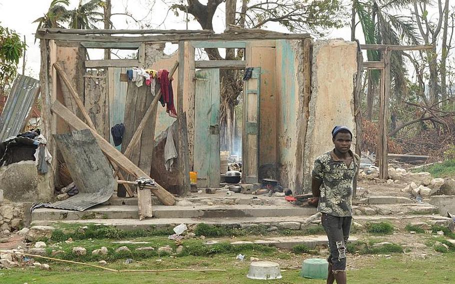 A man stands outside a destroyed home in southwest Haiti on Oct. 17, along the road between the southern coastal city of Les Cayes and the village of Jabouin in the nearby mountains. Hurricane Matthew smacked into the region two weeks ago, leaving an estimated 90 percent of the homes damaged or destroyed.