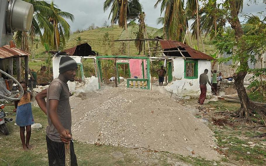 A man stands outside a destroyed home in southwest Haiti on Oct. 17, along the road between the southern coastal city of Les Cayes and the village of Jabouin in the nearby mountains. Hurricane Matthew smacked into the region two weeks ago, leaving an estimated 90 percent of the homes damaged or destroyed. damaged or destroyed.