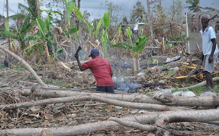 A man chops through a thicket of fallen trees in southwest Haiti on Oct. 17, along the road between the southern coastal city of Les Cayes and the village of Jabouin in the nearby mountains. Hurricane Matthew smacked into the region two weeks ago, leaving an estimated 90 percent of the homes damaged or destroyed.