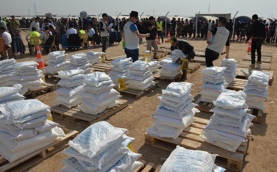 About 200 people lined up on Monday, Nov. 7, 2016, to receive monthly family food rations from the World Food Program, distributed by the Christian relief organization Samaritan's Purse at a displacement camp about 20 miles from Mosul. Nearly 1,300 families were living at the camp after fleeing fighting in and around Iraq's second largest city, which the Islamic State has held for more than two years.