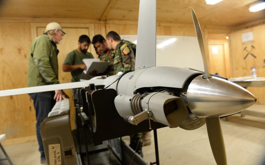 Trainee maintainers check a manual on the ScanEagle unmanned aerial vehicle at a school outside the city of Mazar-e-Sharif on Wednesday, Oct. 26, 2016.