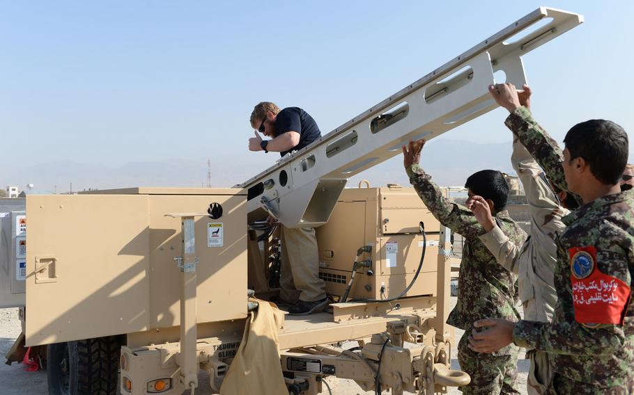 Instructor Cody Cavender helps set up the ScanEagle drone launcher outside a training center near the city of Mazar-e-Sharif on Wednesday, Oct. 26, 2016.
