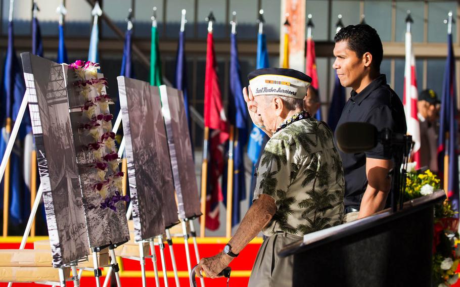 Thomas Petso, 93, salutes a lei-draped image of Hangar 105, during the Wheeler Army Airfield remembrance ceremony, Monday, Dec. 5, 2016. Wheeler was a top target for Japan's 1941 attack.