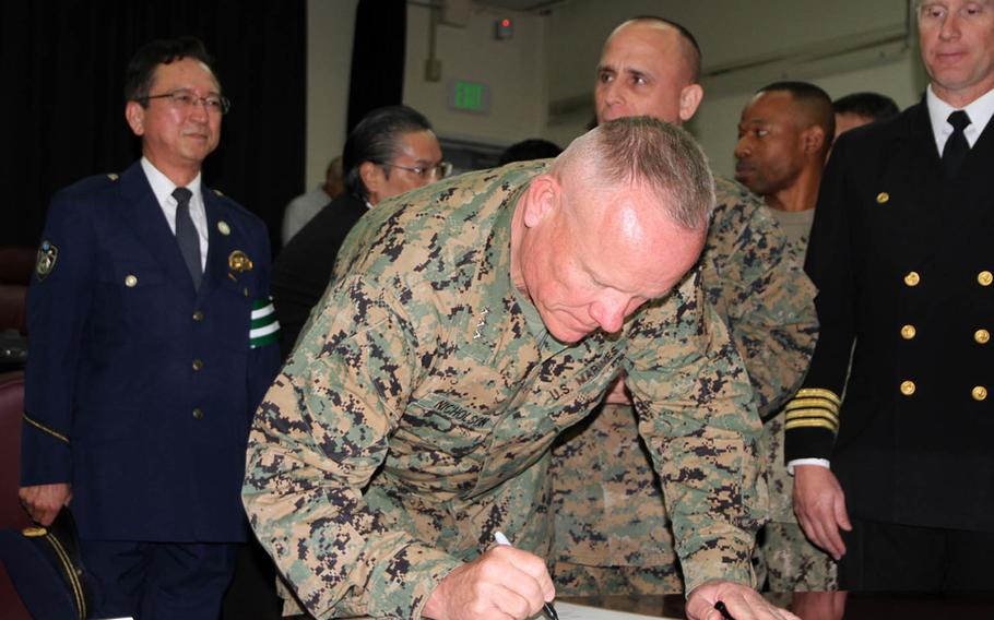 Marine Corps Lt. Gen. Lawrence Nicholson, III Marine Expeditionary Force commander, signs a proclamation Tuesday, Dec. 6, 2016, in Okinawa, Japan. The proclamation launches the Drugged and Drunk Driving Awareness and Prevention Campaign, which will last throughout the holiday season for U.S. forces in Okinawa.