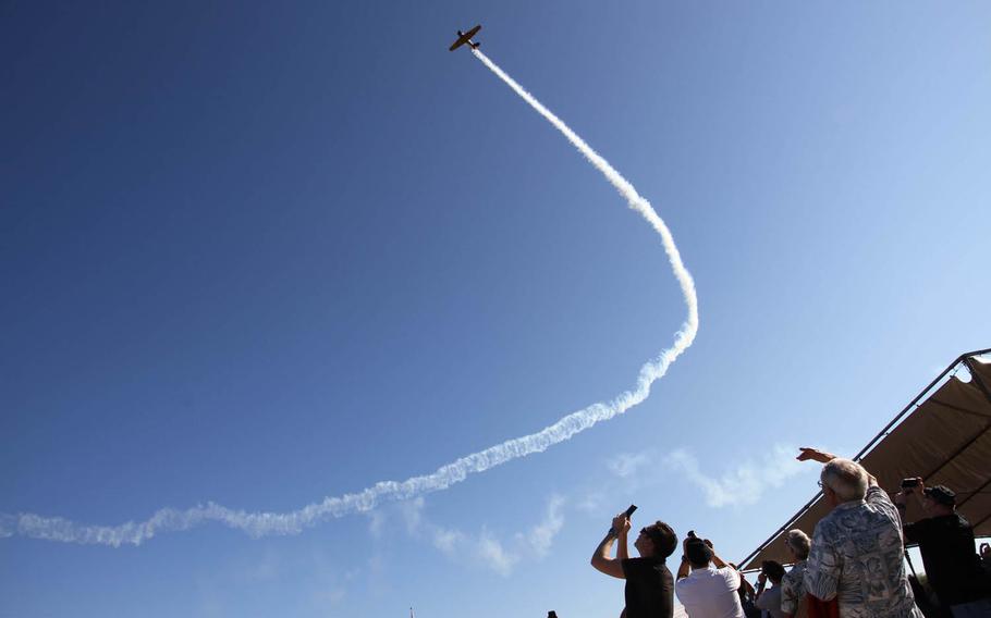 A World War II-era plane flies over a ceremony at Ewa Field, Tuesday, Dec. 6, 2016. The events in Ewa have always been overshadowed by the immense catastrophe that took place at Pearl Harbor, where the U.S. battleship fleet was decimated.