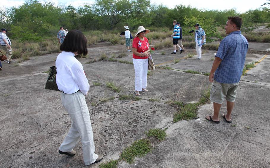 Visitors inspect pock marks left from strafing during Japan's Dec. 7, 1941, surprise attack at Ewa Field, Hawaii. They had attended a ceremony commemorating those who had defended the Marine Corps air station.