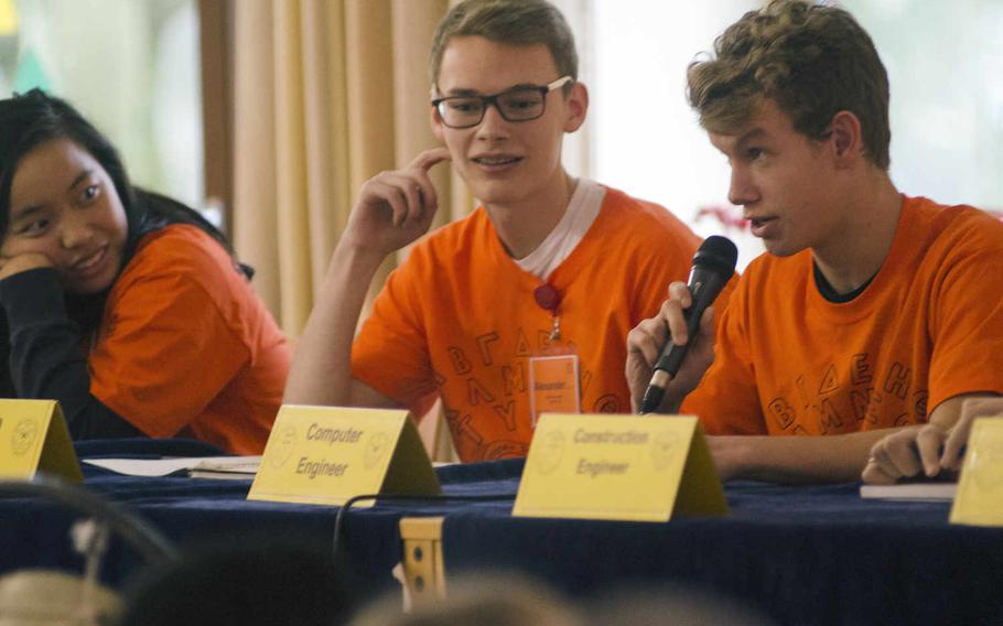 Aidan Newell, right, of Wiesbaden, answers a question during a news conference at STEMposium 2016, Tuesday, Dec. 6, 2016, in Wiesbaden, Germany. Each of the 18 teams in the annual tech event were asked to explain their strategies on this year's scenario - colonizing Mars - in mock news conferences to test their knowledge of the subject.