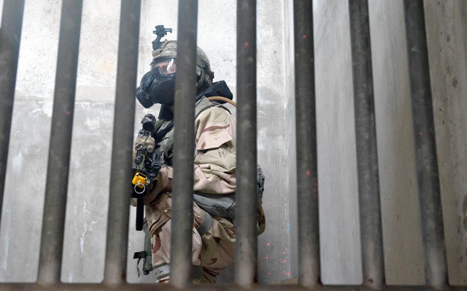 A soldier with the Fort Riley, Kan.-based 3rd Battalion, 66th Armored Regiment, 1st Armored Brigade Combat Team, 1st Infantry Division crouches on a staircase during a drill at Rodriguez Live Fire Range, South Korea, Wednesday, Dec. 7, 2016. The exercise was held with the 501st CBRNE Company as part of training to increase the readiness of troops to confront threat of chemical and biological weapons and nuclear weapons.