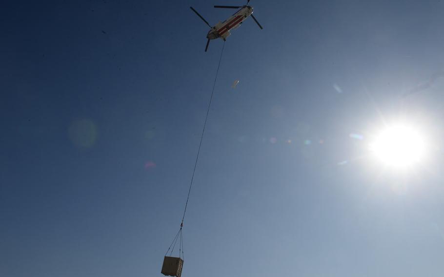 A V-107 helicopter operated by Columbia Helicopters leaves Bagram Air Field, Afghanistan, on Dec. 5, 2016, with cargo. Sling loaders are increasingly busy loading supplies on helicopters to supply smaller bases that lack airfields.