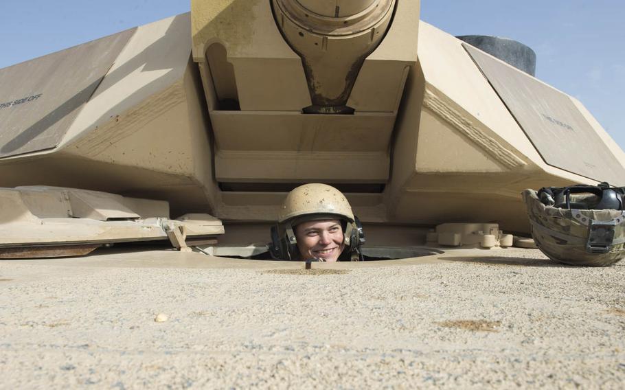 Pfc. Tucker Goodwin, a U.S. Army M1A2 Abrams tank driver, jokes with a fellow crewmember while waiting to start a live fire during a U.S.-Kuwaiti Partnership exercise on Dec. 7, 2016. 