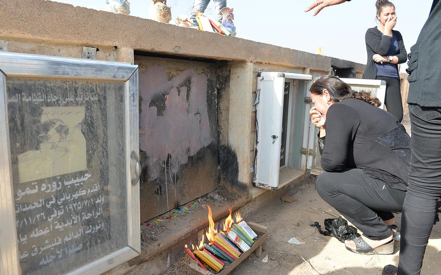 A woman weeps at the tomb of Hadiya Qreo Yohanna in a cemetery near the recently liberated Christian town of Qaraqosh, Iraq, on Nov. 14, 2016. Yohanna fled the town in 2014 as the Islamic State group swept in had asked to be buried in her home village.