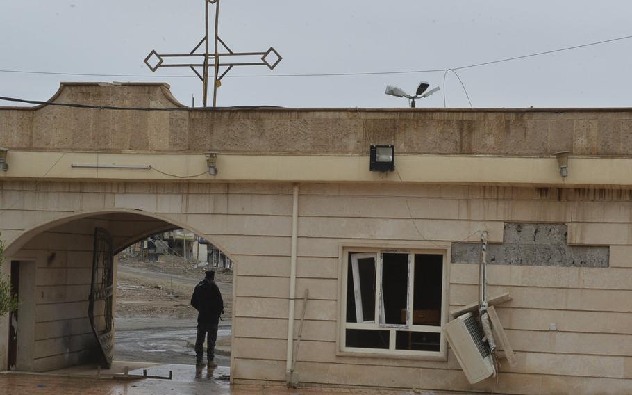 A police officer stands guard outside St. George's Church in Qaraqosh, Iraq, Dec. 17, 2016. The church in this town near Mosul is the site of a former Islamic State munitions manufacturing plant.