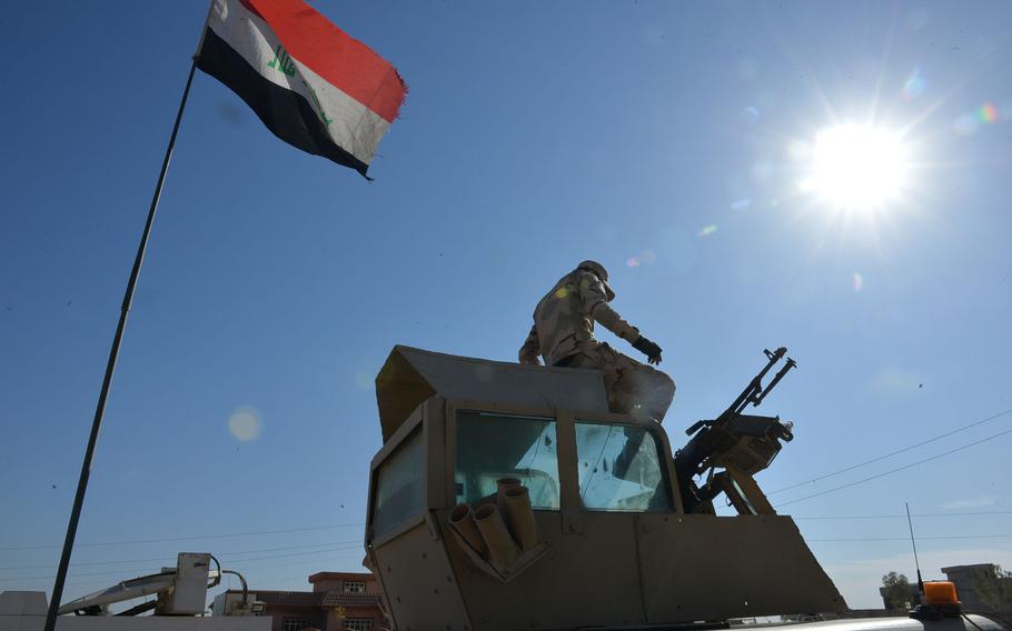 A soldier from Iraq's 9th Armored Division sits atop the turret of his Humvee near Mosul on Nov. 19, 2016.