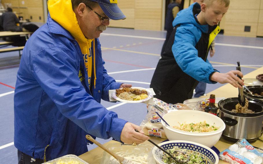 Greg Hatch, principal of Wiesbaden High School, takes some of a potluck dinner at the school's robotics club's season kickoff party, Saturday, Jan. 7, 2017, in Wiesbaden. The potluck preceded the announcement of the theme and specifications for the FIRST Robotics Competition.
