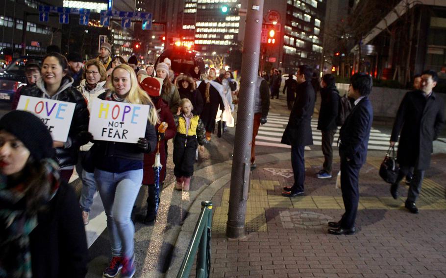 Tokyo office workers wait to cross as the Women's March in Tokyo procession continues on Jan. 20, 2017.
