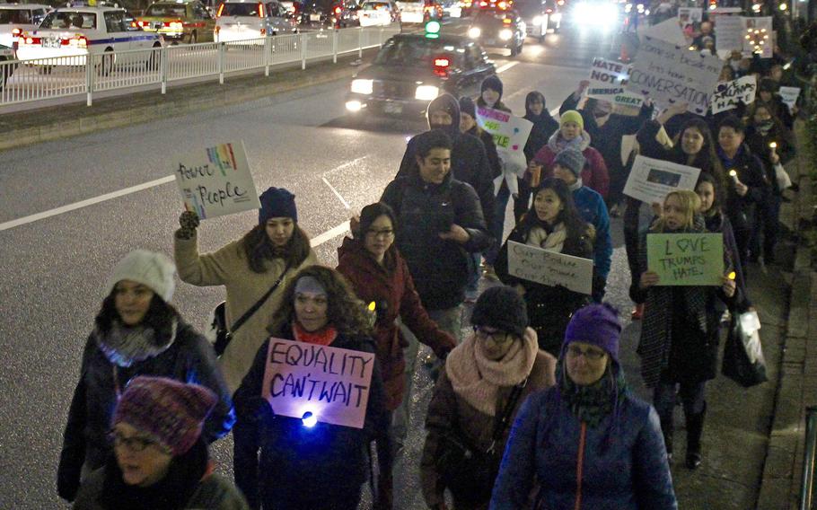 Participants of the Women's March in central Tokyo share the road with traffic on Jan. 20, 2017.