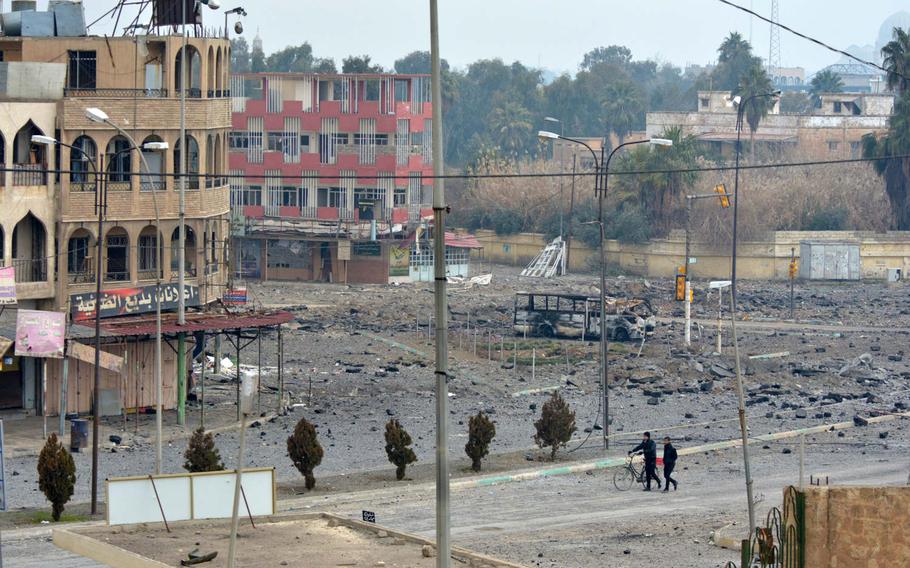 Residents walk through a liberated neighborhood in Mosul, Iraq, on Saturday, Jan. 21, 2017.