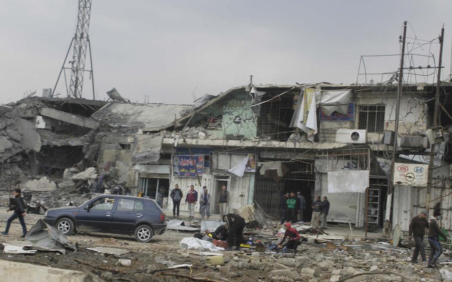 Residents clear up damage from fighting in Mosul, Iraq on Saturday, Jan. 21, 2017. 