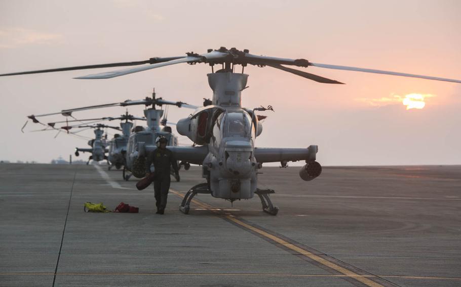 A Marine walks near an AH-1Z Viper at Marine Corps Air Station Futenma, Okinawa, Dec. 2, 2016. One of the attack helicopters made a precautionary landing on Ikei Island, Okinawa, late last week after pilots received a warning indication in the cockpit.