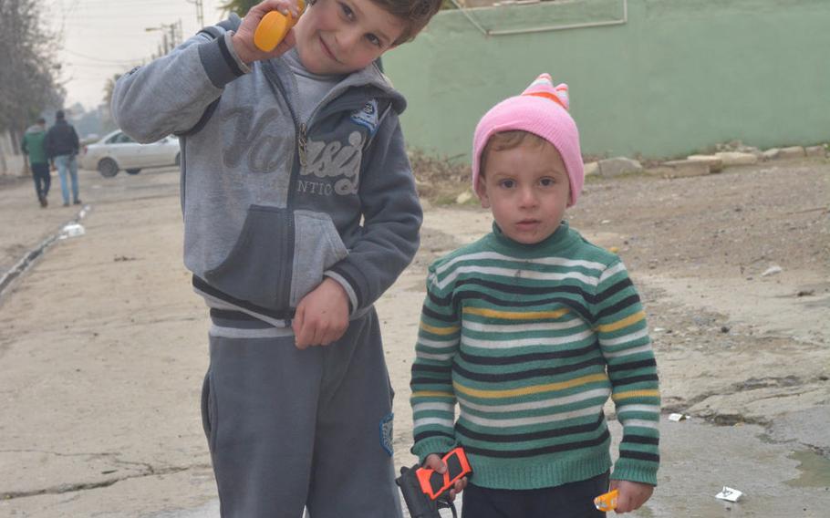 Kids with toy guns play in Mosul's Hay al-Arabi neighborhood Wednesday, Jan. 25, 2017.