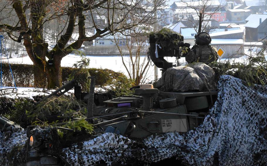 A soldier with 4th Reconnaissance Squadron, 2nd Cavalry Regiment, looks over a German village during part of maneuver training, Thursday, Feb. 2, 2017.