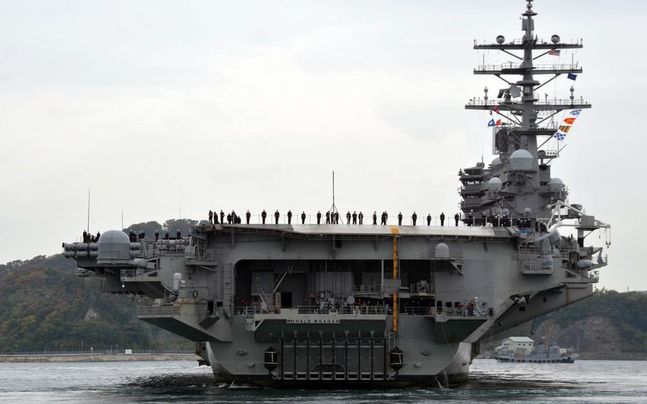 Sailors man the rails on board the aircraft carrier USS Ronald Reagan as it returns to Yokosuka Naval Base, Japan, in November.