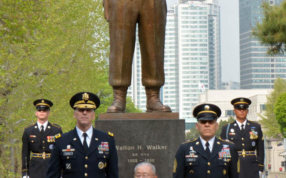 Lt. Gen. Thomas Vandal, from left, 8th Army commander, retired South Korean Gen. Paik Sun-yup and Command Sgt. Maj. Richard Merritt pose in front of the bronze statue of Korean War hero Lt. Gen. Walton Walker at Yongsan Garrison in Seoul, South Korea, Tuesday, April 25, 2017.