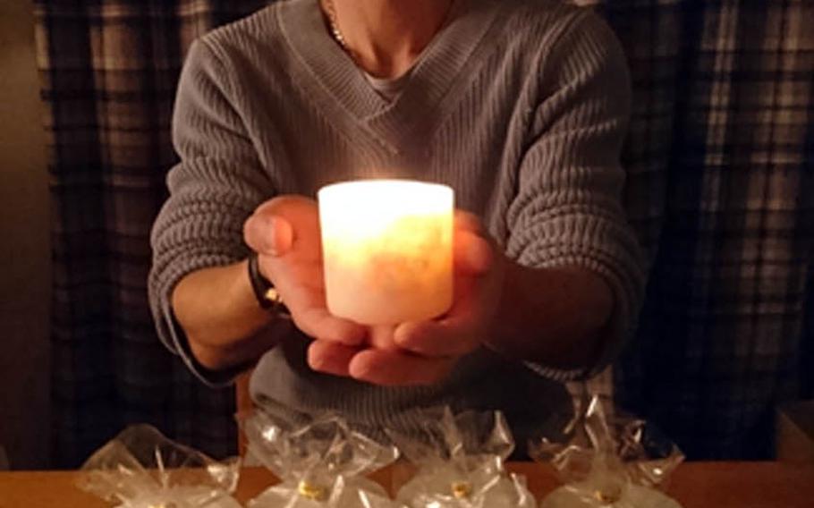 Eric Billingsley, 43, of Hiroshima holds one of his Hiroshima Candles, which incorporate pieces of origami cranes left at Hiroshima's Peace Memorial Park into their wax.